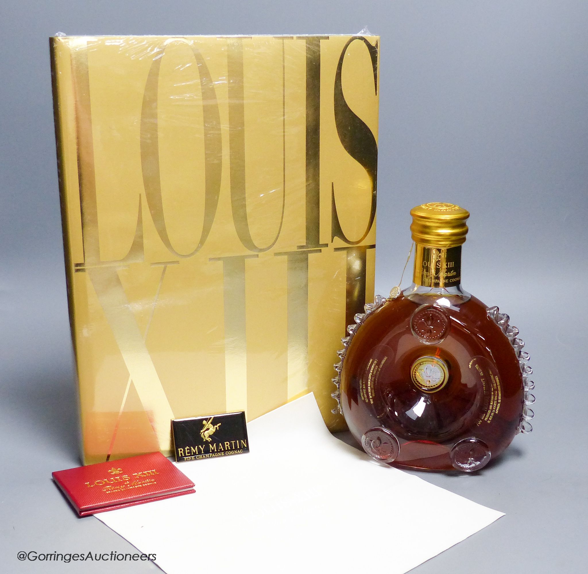 A sealed bottle of Louis XIII Remy Martin Grand Champagne Cognac, Carafe No.DJ9508, with original cloth and a sealed copy of Louis XIII Cognac The Thesaurus